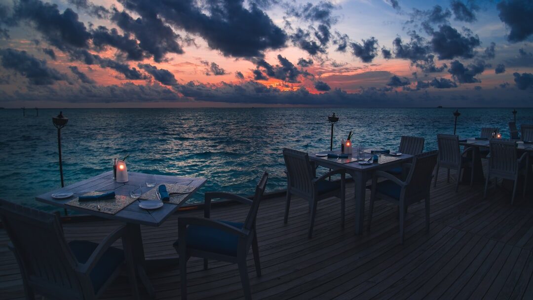 Waterfront restaurant terrace with dining tables at sunset