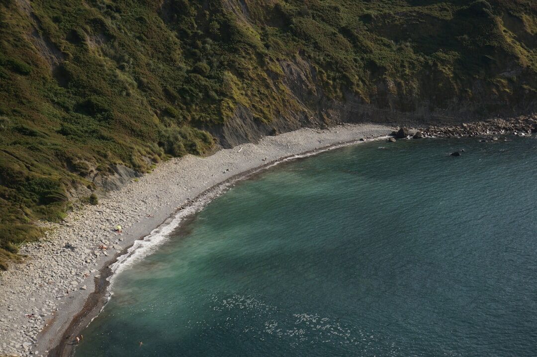 Empty pebble beach cove at sunrise with soft pink light