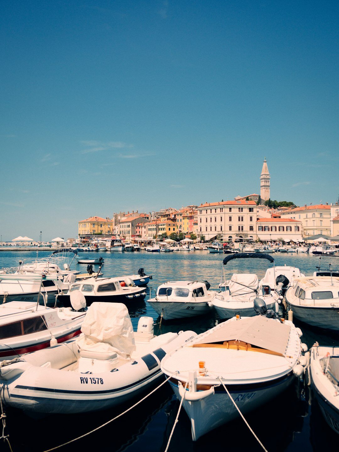 Rows of colorful boats along Rovinj harbor wall