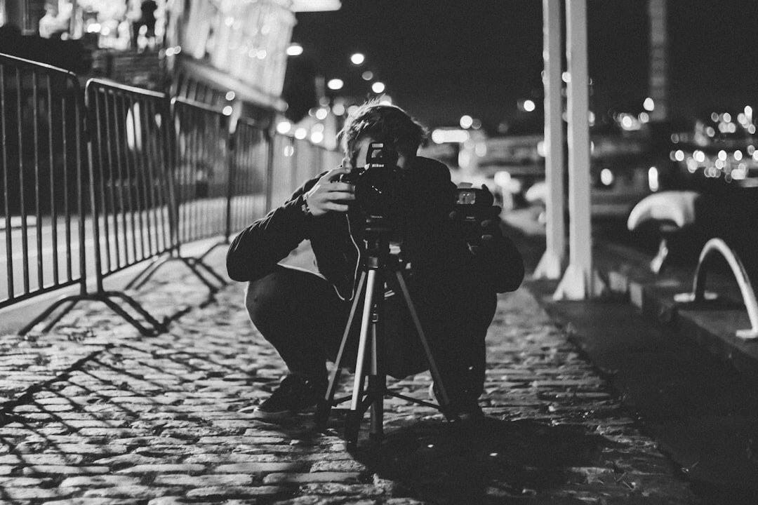 Photographer crouching to photograph street scene