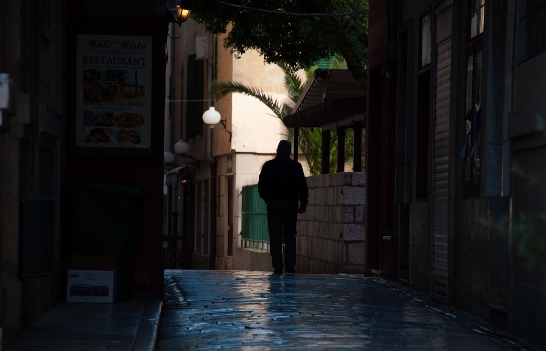 Pedestrians exploring Zadar old town alleys with guidebook